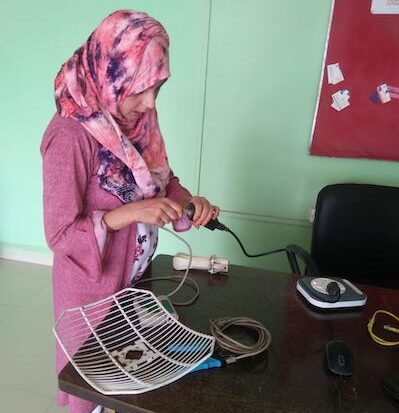 Una mujer instalando una antena.