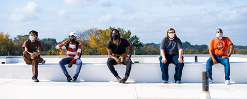 Five men sitting on concrete