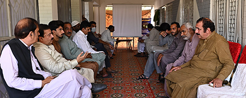 Pakistani men sitting on two benches across each other
