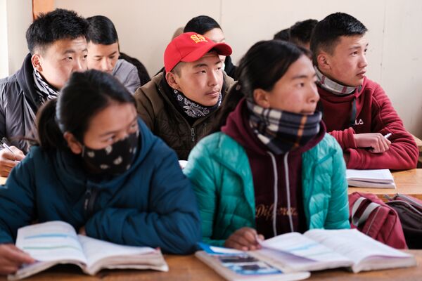Students sitting in class with books opened