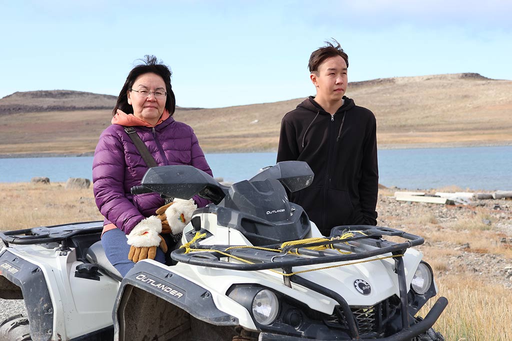 a woman and a boy on a quad outside