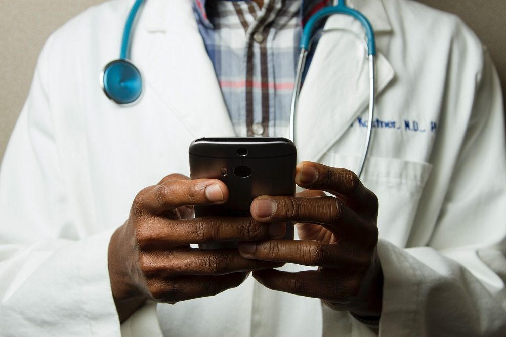 Médico con el móvil en la mano.