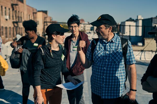 A group of people engaged in conversation while standing on a rooftop