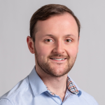 A man with a blue shirt smiling