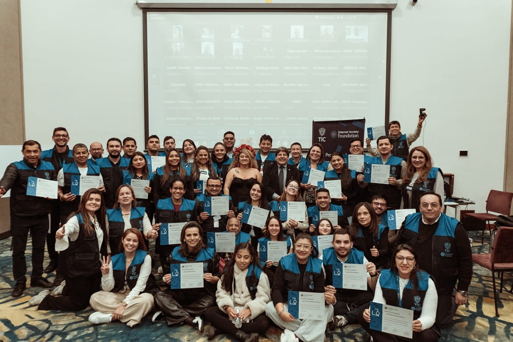 Students holding diplomas and posing for group photo