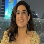 A woman in a yellow blouse smiling