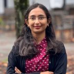 woman in cyclamen polka dot shirt and black cardigan